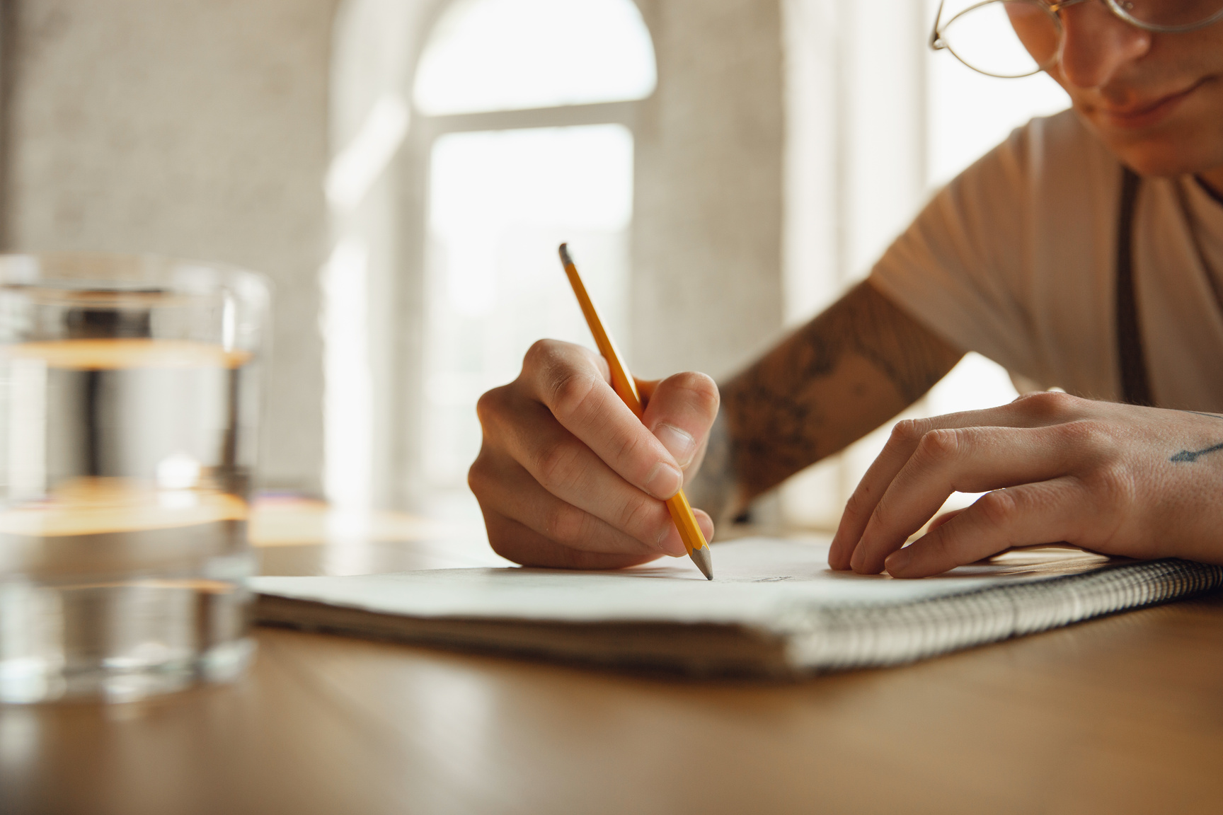 Close up of a Man Writing on a Notebook
